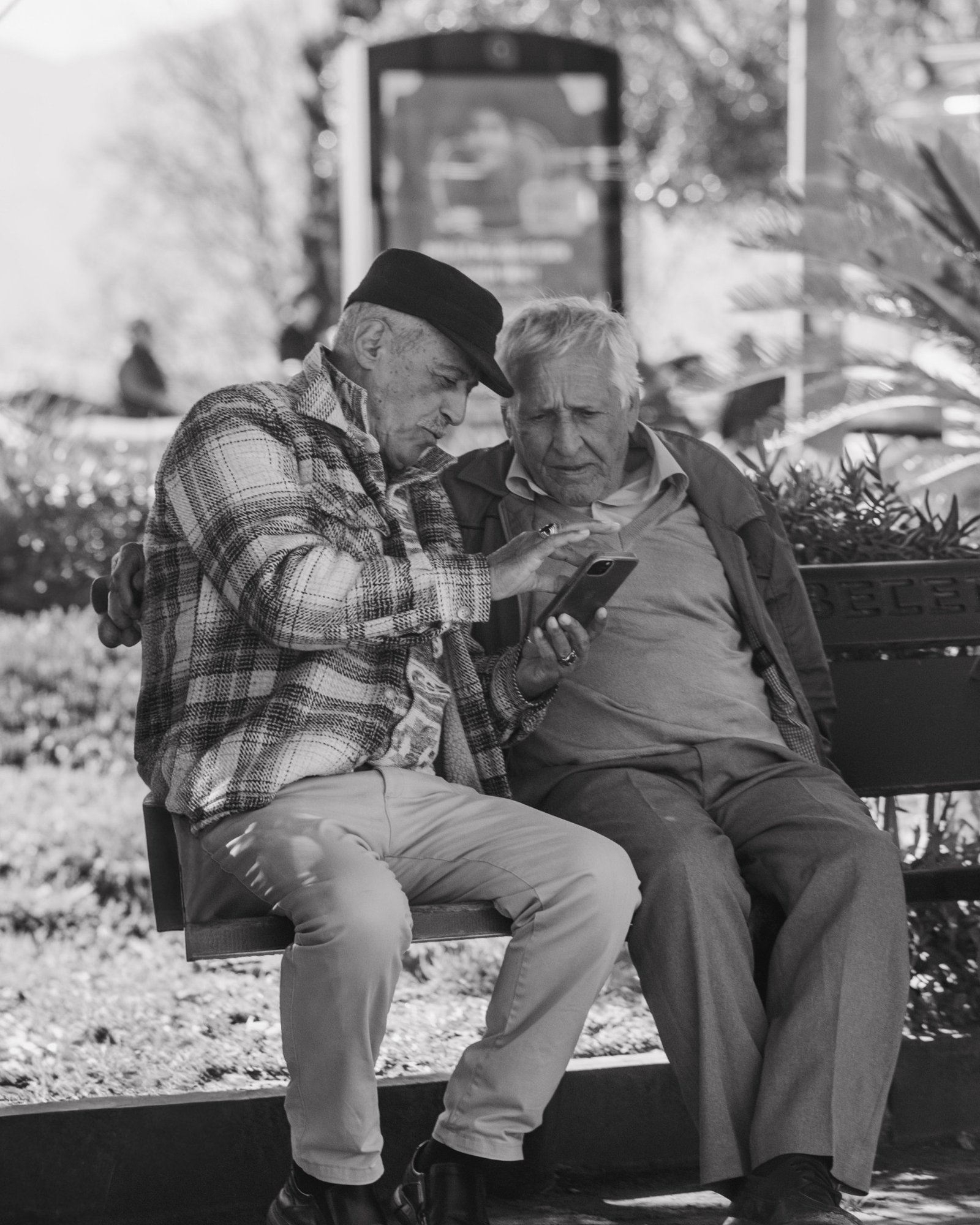 Senior citizens using a phone while seated in the garden